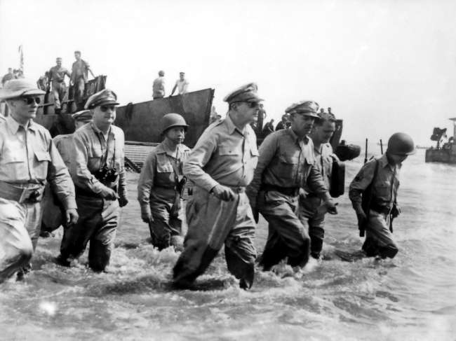 Gen. Douglas MacArthur wades ashore during initial landings at Leyte, Philippine Islands